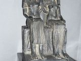 a statue of two women sitting on a bench