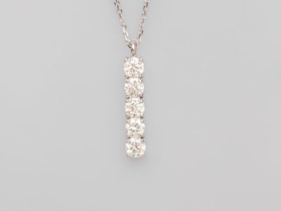 un pendentif en diamant de trois pierres, monté sur une chaîne en argent
