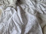a white dress on a bed next to a pillow