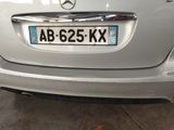 a silver car parked in a garage with a number plate on it