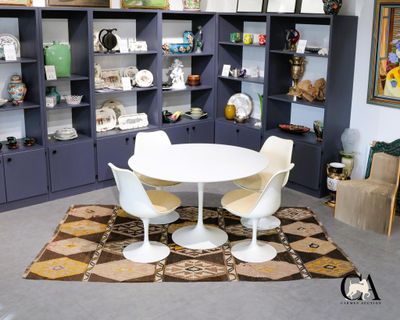 une table et des chaises blanches dans une pièce avec des étagères bleues