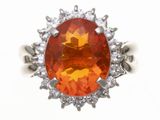 une image représentant une bague ornée d'une pierre orange entourée de diamants blancs