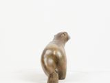 sculpture of a bird sitting on a rock on a white surface