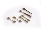 four different types of brass screws and a hammer on a white surface