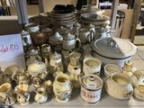 une table sur laquelle sont disposées de nombreuses pièces de poterie