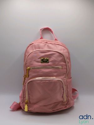 un sac à dos rose posé sur une table blanche