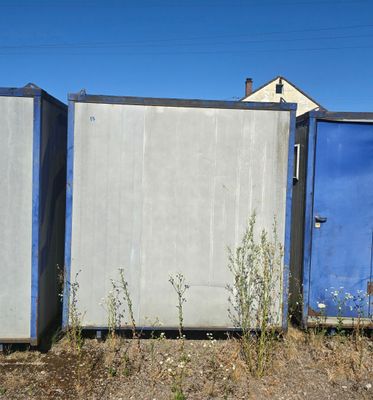 three blue and white toilets in a row on the side of the road