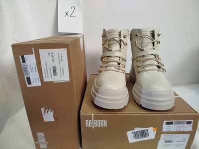une boîte sur laquelle sont posées deux paires de chaussures blanches