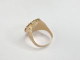 a close up of a gold signet ring on a white surface