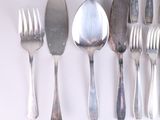 a lot of silver spoons and forks on the table