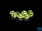 a close up of a group of green gems on a black surface