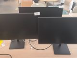 trois écrans d'ordinateur posés sur une table dans un magasin
