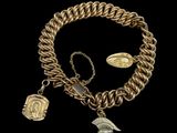 un gros plan sur un bracelet à chaîne en or orné de breloques