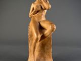 an image of a statue of a woman sitting on top of a wooden block