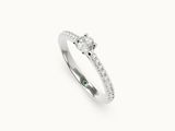 une bague sertie d'un diamant et d'une émeraude sur fond blanc