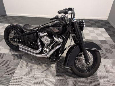 une moto noire garée sur un sol à damier