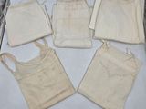 Plusieurs sacs en tissu sont disposés sur une feuille de papier