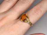 an image of a woman ' s hand with a yellow ring on it