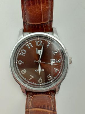 une image d'un gros plan d'une montre-bracelet sur une surface blanche