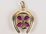 an image of a gold pendant with a purple flower in the center
