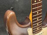 an electric guitar is sitting on a stand on a black surface
