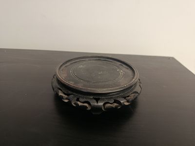 a small metal object on a table with a white wall in the background