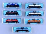 six wagons de train miniature sont alignés en rang sur une surface bleue
