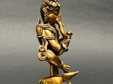brass statue of a man on a fish with a crown on his head