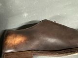 brown leather slippers with a wooden heel on a gray surface