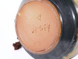 a close up of a vase with a brown lid