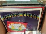 a lot of records in a cardboard box on the floor