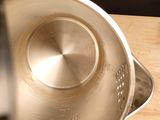 a metal bowl with a metal lid on a wooden table