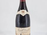 a close up of a bottle of wine on a white surface