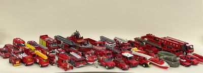 beaucoup de camions de pompiers miniatures posés sur la table