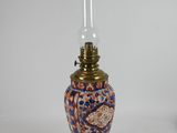 pair of oriental vases with candles on stands on a white surface