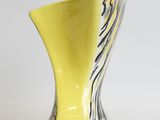 a yellow vase with black and white stripes on it