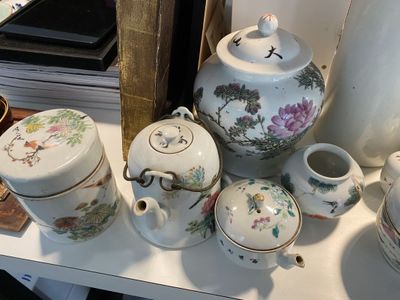 une table blanche sur laquelle sont disposés plusieurs vases différents