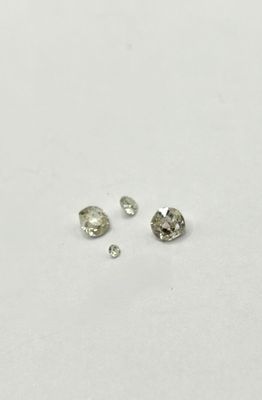 a group of three different sized diamonds on a white surface