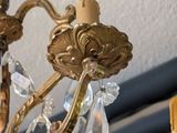 a gold chandelier with crystal drops hanging from it