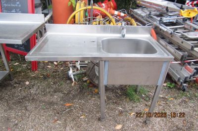 un évier en inox et une table dans un jardin