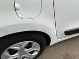 a small white car parked on the side of the road