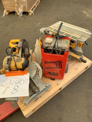 une caisse d'outils posée sur une palette, sur laquelle est accrochée une pancarte