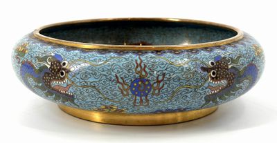 a blue bowl with fish on it on a white surface