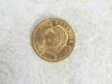 a close up of a gold coin on a white surface