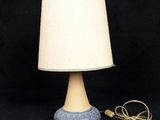 a blue and white table lamp with a white shade on it