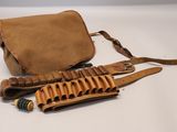 une photo d'un sac en cuir marron contenant un fusil de chasse, posé sur une surface blanche