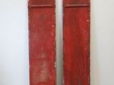 pair of antique red painted wooden shutters with metal brackets