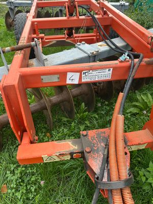 a tractor with a plow attached to it in the grass