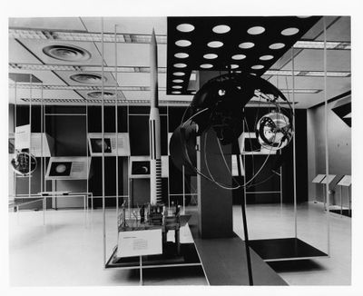 photographie en noir et blanc représentant une sculpture d'un homme dans une pièce remplie de miroirs