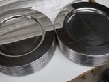 two silver plates sitting on a table with a camera next to them